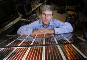 Professor John Bell with a pane of the solar cell glass. Credit: QUTErika Fish