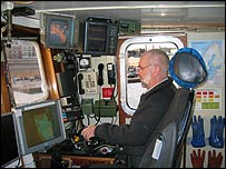 Captain of ship with screens in front of him