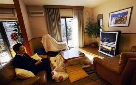 Masanori Naruse sits back on a couch at his home in Hiratsuka near Tokyo Japan Thursday Feb. 21 2008.  Naruses home gets its electricity and hot water from power generated by a hydrogen fuel cell. (AP PhotoJunji Kurokawa)