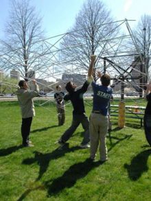 Harnessing sunlight on the cheap MIT students work on a new kind of solar generator that employs low-cost materials. Here they mount the frame of the concentrator (which will be mounted with mirrors) on the base near Tang Hall on Memorial Drive. Photo  Donna Coveney