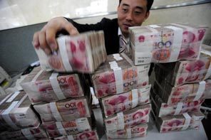 A bank clerk stacks up renminbi bank notes in central China's Anhui