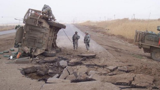 A Stryker lies on its side following a buried IED blast in Iraq in 2007