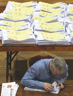 An election worker recounts ballots as ballot boxes are opened and counting begins for the Irish General Election at the Theatre Royal count centre in Castlebar, Ireland, yesterday. Photo: AFP