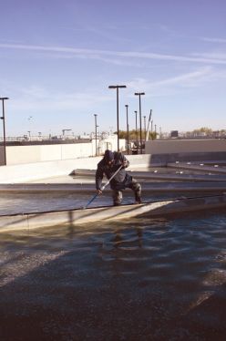 Utility Plant Technician scrubs calcium accumulations from the lime reactor 