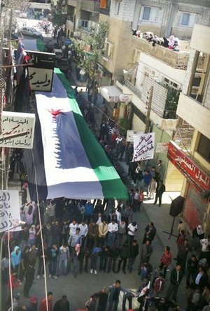 
In this image provided by the Local Coordination Committees in Syria and accessed on Friday, April 13, 2012, anti-regime protesters carry a large Syrian revolutionary flag during a demonstration in Damascus, Syria.  Syrian troops shelled residential neighborhoods dominated by rebels in the central city of Homs Sunday, activists said, hours before the first batch of United Nations observers were to arrive in Damascus to shore up a shaky truce.(AP Photo/Local Coordination Committees in Syria) THE ASSOCIATED PRESS IS UNABLE TO INDEPENDENTLY VERIFY THE AUTHENTICITY, CONTENT, LOCATION OR DATE OF THIS HANDOUT PHOTO
