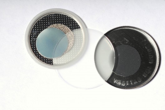 Components of a new self-charging piezoelectric power cell  the clear disc in the center ...