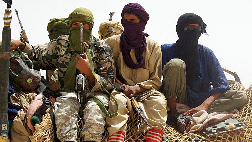 Fighters from Islamist group Ansar Dine stand guard at a designated rendezvous point in the desert outside Timbuktu, Mali. The radical militants continued to destroy ancient tombs designated as UNESCO heritage sites on Monday, amid a growing international outcry.
