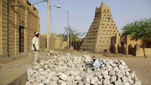 Men work alongside one of Timburktu's historic mud mosques, in Timbuktu, Mali, in this May 2011 file photo.