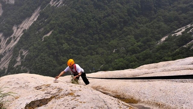 Just another day at the office: A sanitation worker cleans garbage from the cliffs on Mount Hua in China.