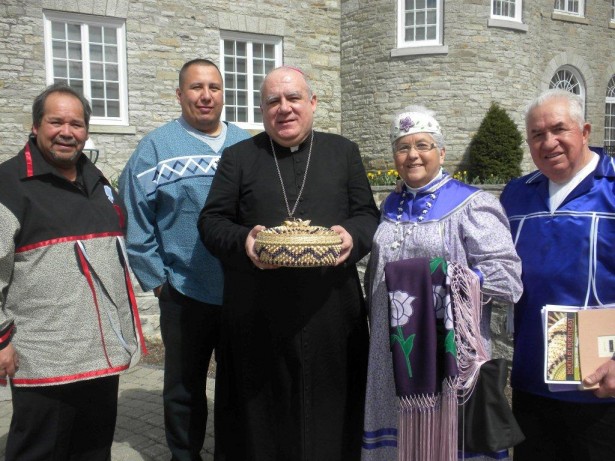 Archibishop Lopez Quintano, the Apostolic Nuncio to Canada, holds a basket made by Mohawk basketmaker Sheila Ransom that will be presented to Pope Benedict XVI by the Mohawk delegation to the canonization of Kateri Takakwith. To his right in the photo are Alma and Orlo Ransom; to his left are tribal police Detective Matt Rourke and former St. Regis Mohawk Tribe Chief Wally Oaks.