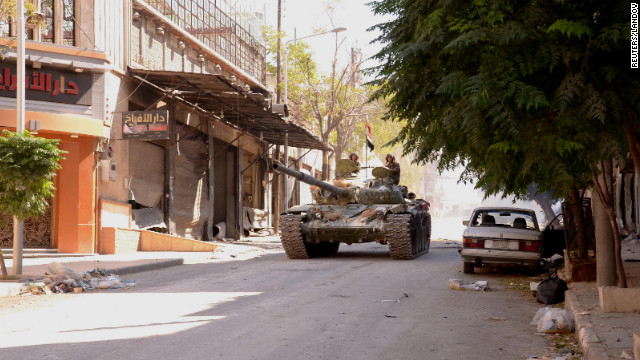 Soldiers loyal to President Bashar al-Assad travel in a Syrian Army tank in Aleppo, Syria, on Sunday, September 23, after clashes between Free Syrian Army fighters and regime forces.