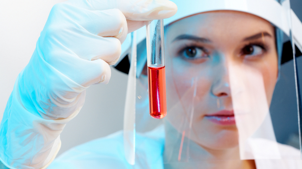 A scientist examines a vial. Photo: Shutterstock.com.