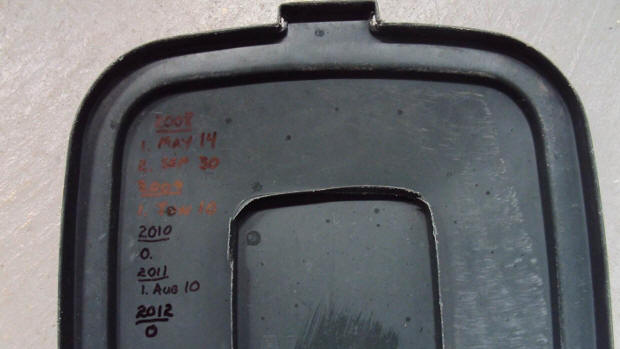 The top of Shawn Williamson's garbage can marks the dates he has had to roll it to the curb since 2008.
