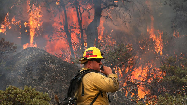 U.S. Forest Service firefighter Chris Brossard talks on his radio while monitoring a spot fire while battling the Rim Fire Aug. 24, 2013, in Yosemite National Park, Calif.