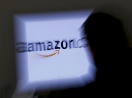 A zoomed illustration image of a man looking at a computer monitor showing the logo of Amazon is seen in Vienna November 26, 2012. REUTERS/Leonhard Foeger