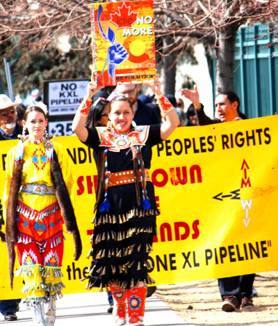 Marchers at a 30-organization climate crisis rally in Denver headed toward downtowns Civic Center Park, with Idle No More leaders Cheyenne Birdshead (left) and Taryn Soncee Waters heading up the line. (Carol Berry)