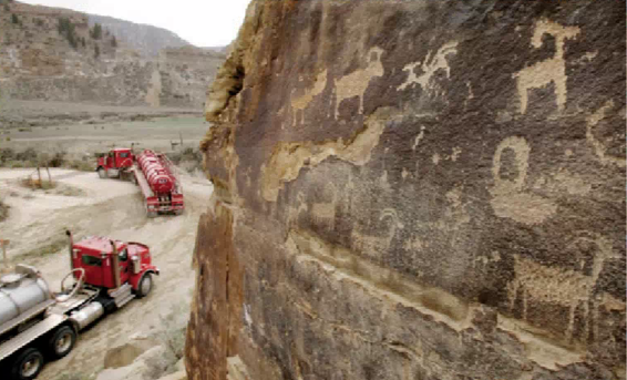 Tanker trucks pass petroglyphs in Utah, where a deal was struck with an energy company to protect them. (AP)