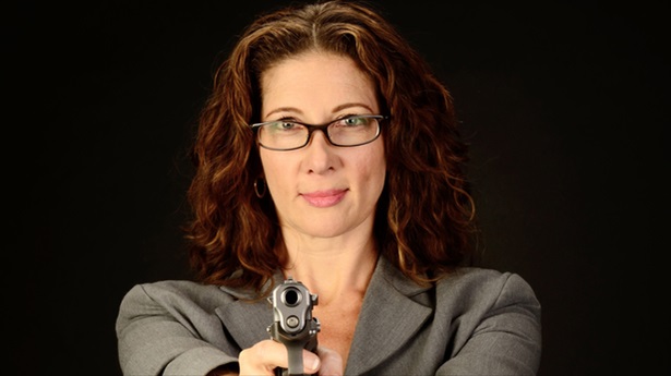 'A Middle Aged, White, Female Business Woman Or Teacher Holds A Semi Automatic Pistol' [Shutterstock]