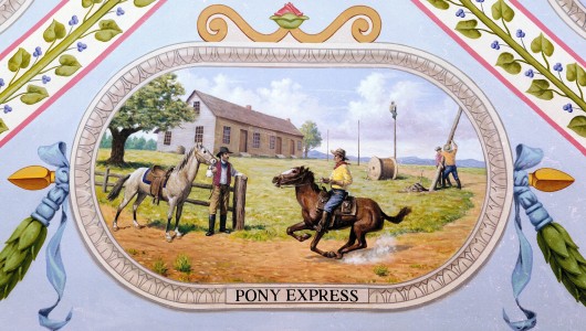 A modern painting of a Pony Express station where two riders are passing the mail on, whil...