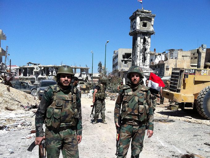 Syrian government soldiers stand in the main square of al-Qusayr on June 5 after capturing the town from rebel forces. The town was the rebels' principal transit point for weapons and fighters from neighboring Lebanon.