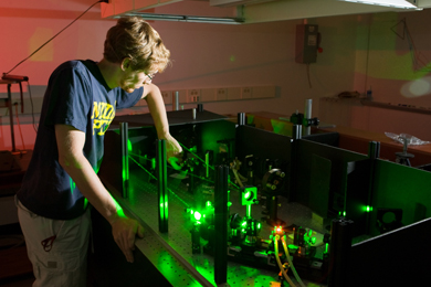 William Fisher operates a device that bounces laser light around a transparent box.