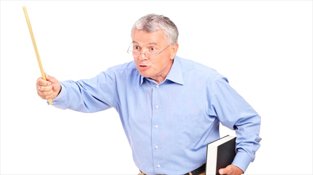 'An angry mature teacher holding a wand and gesturing' via Shutterstock