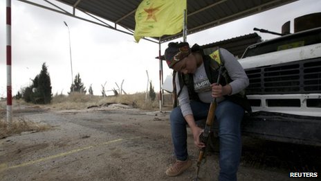 A female member of the Kurdish People's Protection Units (YPG) checks her weapon in Al-Rmelan, Qamshli province