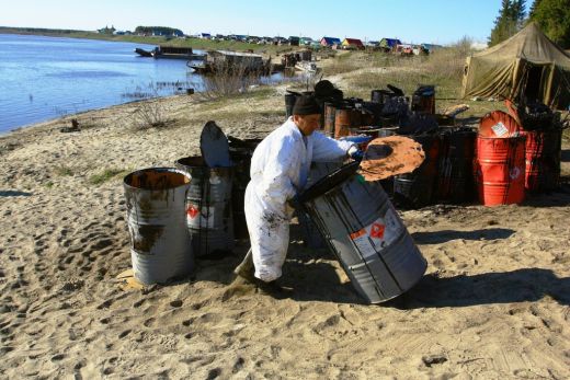 A resident helps clean up the Kolva River oil spill/Credit: Greenpeace