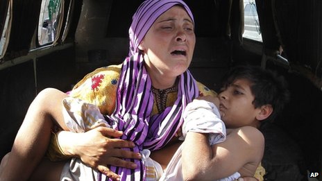 A Syrian mother carrying her injured son escapes into Lebanon (file photo)
