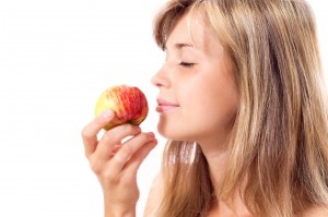 beautiful girl smelling a red juicy apple