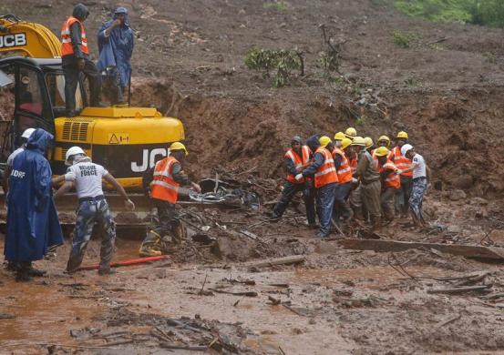 Indian rescuers slog through waist-deep mud to dig out submerged village houses after landslide Photo: Shailesh Andrade
