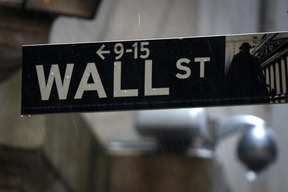 A Wall Street sign is pictured in the rain outside the New York Stock Exchange in New York June 9, 2014.     REUTERS-Carlo Allegri-Files