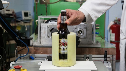 A bottle of beer is cooled using the new magnetic refrigeration system developed by GE
