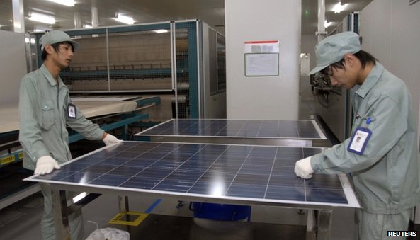 Workers in China holding solar panels