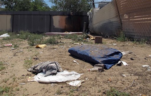 Bedding, clothing and broken glass litter a homeless encampment in Albuquerque, Monday, July 21, 2014, where three teenagers are accused of fatally beating two homeless Navajo men. (Jeri Clausing/AP Photo)