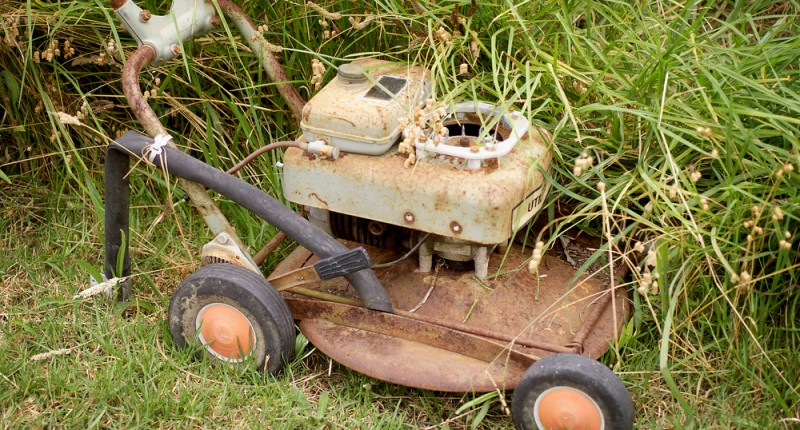 Junked lawn mower in high weeds (Shutterstock.com)
