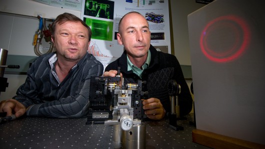 Dr Vladlen Shvedov (left) and Dr Cyril Hnatovsky (right) with a magnified projection of th...