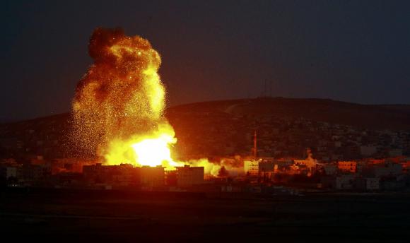 Smoke and flames rise over Syrian town of Kobani after an airstrike, as seen from the Mursitpinar border crossing on the Turkish-Syrian border in the southeastern town of Suruc in Sanliurfa province, October 18, 2014.  REUTERS/Kai Pfaffenbach