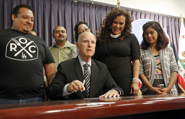California Gov. Jerry Brown signs a bill mandating the paid leave that supporters say will guarantee that workers don&#8217;t lose their jobs or their