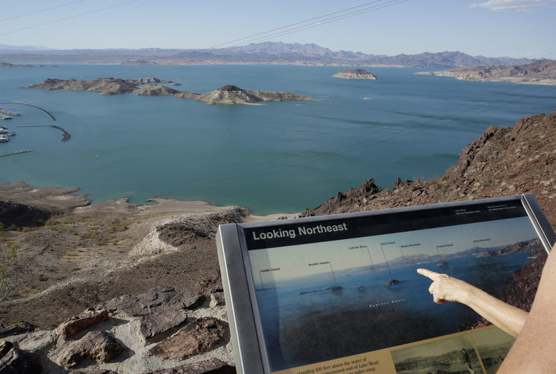 Dropping water levels reveal larger islands in Lake Mead compared with a picture on an interpretive sign overlooking the lake in the Lake Mead National Recreation Area in Nevada. A 14-year drought has caused the water level in the reservoir to shrink to its lowest point since it was first filled in the 1930s.