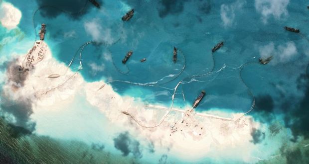 A satellite image shows Chinese dredgers at  Mischief Reef, part of the Spratly Islands, in the South China Sea, last Month. There is evidence that China is aggressively building artificial reef in the area. Photograph: Asia Maritime Transparency Initiative/New York Times