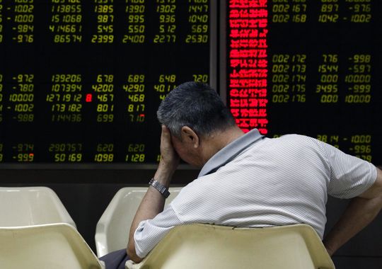 An investor reacts while monitoring stock data on an