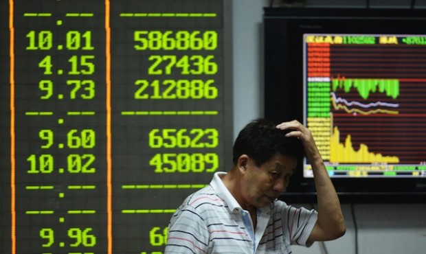 An investor gestures in front of screens showing share prices at a securities firm in Hangzhou, in eastern China's Zhejiang province on August 24, 2015. Shanghai shares nosedived 8.49 percent on August 24 as Beijing's latest market intervention failed to restore confidence, with concern mounting about the stalling economy. (Photo: STR/AFP/Getty Images)