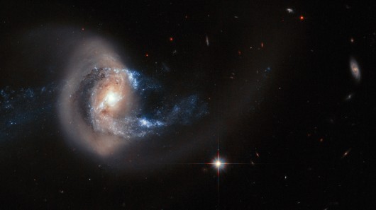 Hubble composite showing the larger galaxy NGC 7714 having its structure deformed by the n...
