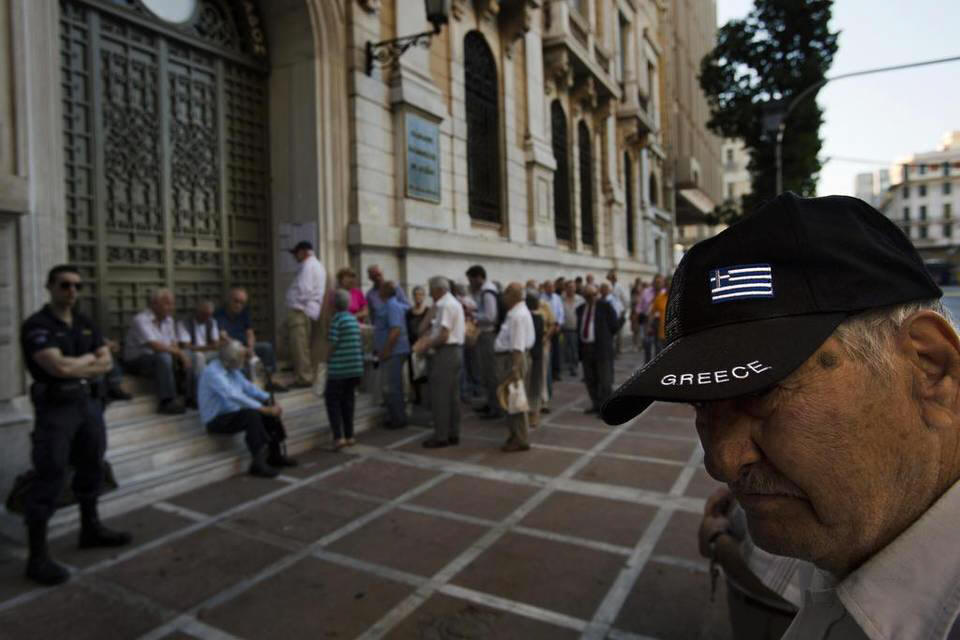 Pensioners wait outside the main gate of the national bank of Greece to withdraw a maximum of 120 euros ($134) in central Athens, Thursday, July 9, 2015.