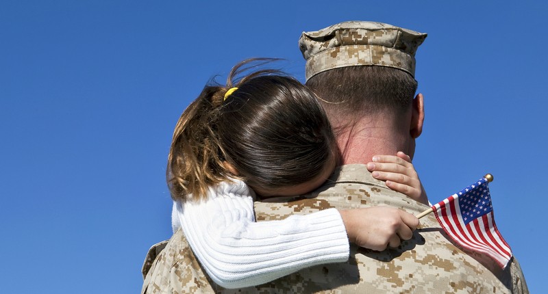 Military man hugs daughter (Shutterstock)