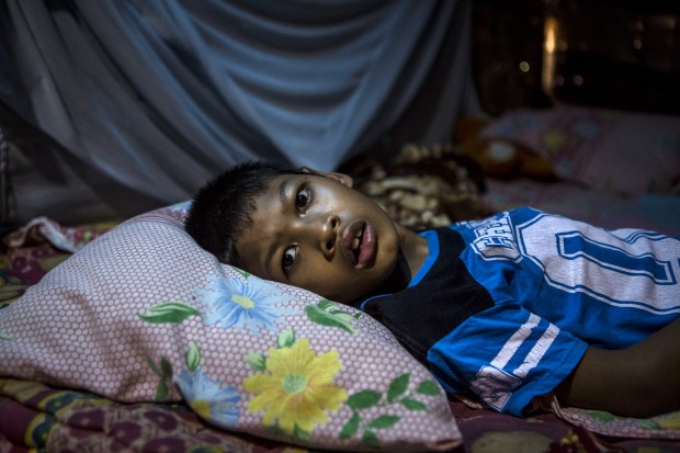 Faiz lies on the bed inside the house at Sidoarjo Village in Jambon subdistrict on March 25, 2016 in Ponorogo district, Indonesia. (Photo by Ulet Ifansasti/Getty Images)