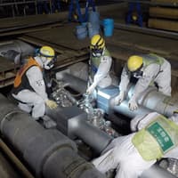 Fukushima workers pour brine into the refrigerated pipes