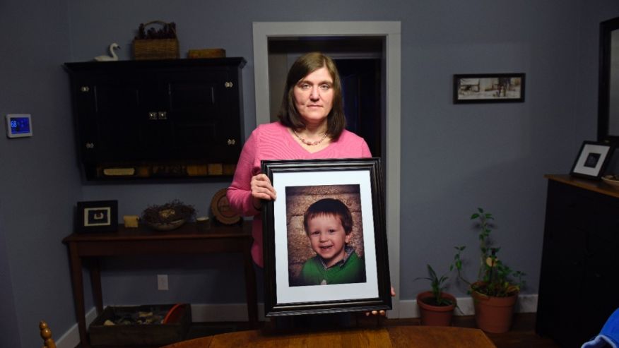 Hollie Ayers poses with a photograph of her late son, Michael, at her home in Bedford, Pa.