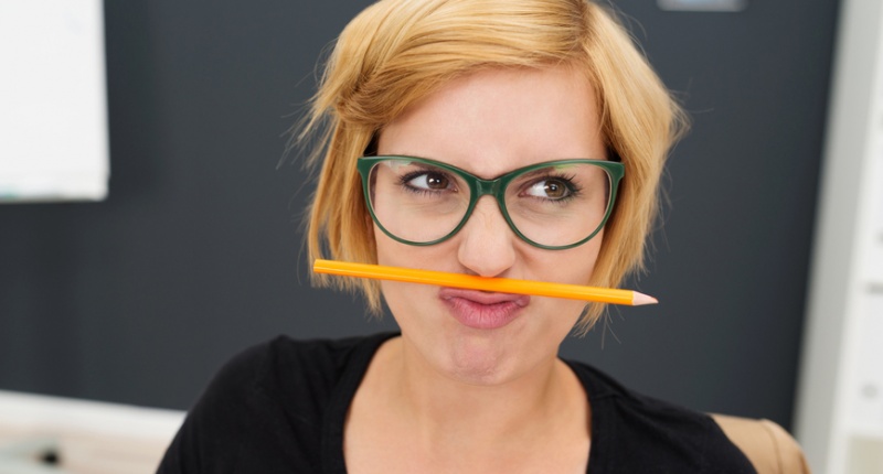 Macro Young Pretty Woman Putting Pencil Between Nose and Lip at Office via Shutterstock.com